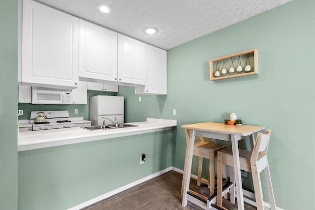 4635 Shalers Dr Unit 44D, Columbus, OH 43228 - kitchen with white appliances, white cabinets, light countertops, recessed lighting, and a textured ceiling