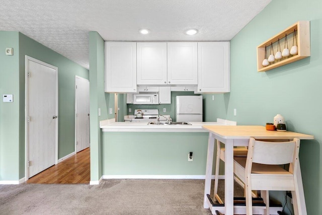 4635 Shalers Dr Unit 44D, Columbus, OH 43228 - kitchen with white appliances, a textured ceiling, carpet, white cabinetry, and a peninsula