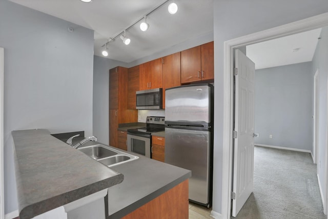 336 S 3rd St Unit 3, Columbus, OH 43215 - kitchen featuring stainless steel appliances, dark countertops, brown cabinets, and a peninsula
