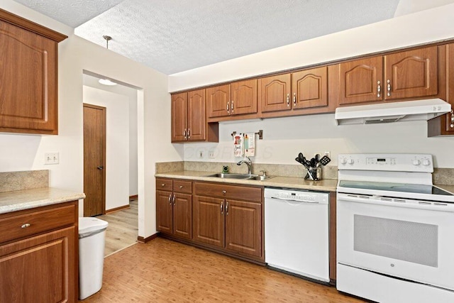 8000 Leaview Dr, Columbus, OH 43235 - kitchen with white appliances, under cabinet range hood, light wood-type flooring, brown cabinets, and light countertops