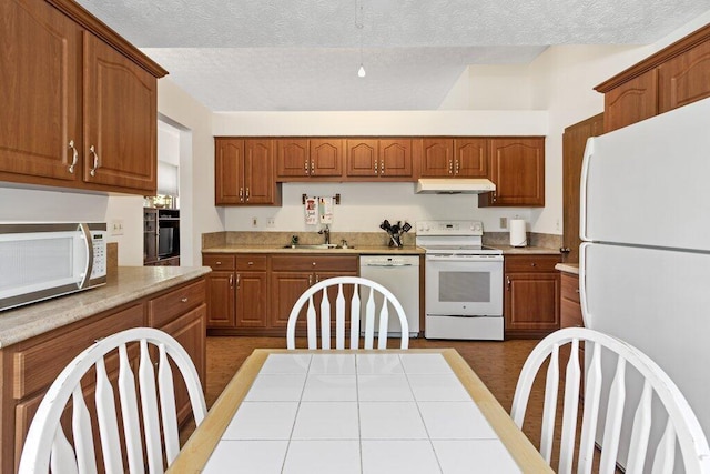 8000 Leaview Dr, Columbus, OH 43235 - kitchen featuring white appliances, exhaust hood, light countertops, brown cabinetry, and a textured ceiling