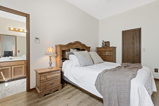 8000 Leaview Dr, Columbus, OH 43235 - bedroom with vaulted ceiling, light wood finished floors, and ensuite bath