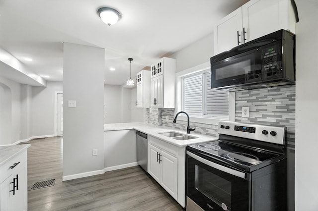 668 Bulen Ave, Columbus, OH 43205 - kitchen with appliances with stainless steel finishes, light countertops, decorative backsplash, light wood-style floors, and white cabinetry