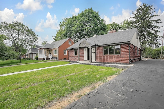 2850 E Moreland Dr, Columbus, OH 43209 - view of front facade featuring brick siding, a chimney, a front lawn, and a shingled roof