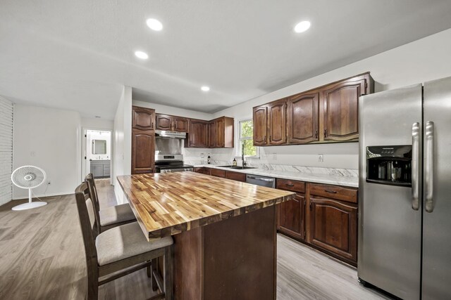 8149 Outville Rd SW, Pataskala, OH 43062 - kitchen with appliances with stainless steel finishes, light wood-style flooring, wooden counters, a breakfast bar area, and dark brown cabinetry