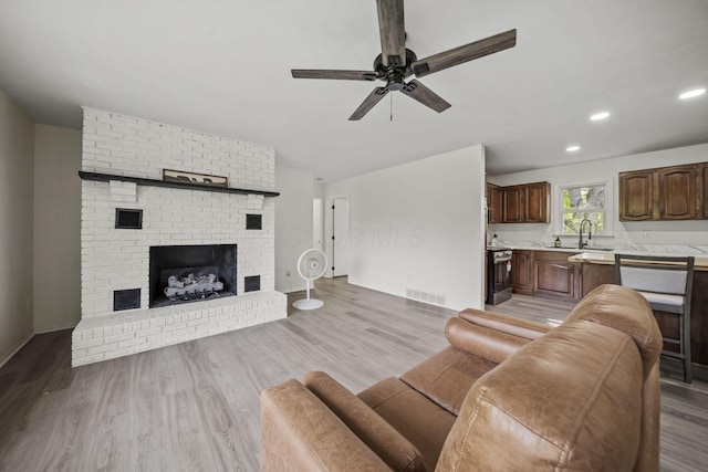 8149 Outville Rd SW, Pataskala, OH 43062 - living room with ceiling fan, a fireplace, light wood-style flooring, and recessed lighting