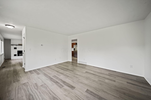 8149 Outville Rd SW, Pataskala, OH 43062 - spare room with wood finished floors and a brick fireplace
