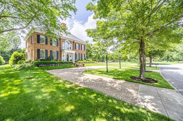 4791 Yantis Dr, New Albany, OH 43054 - view of front facade with a front yard, brick siding, and a chimney