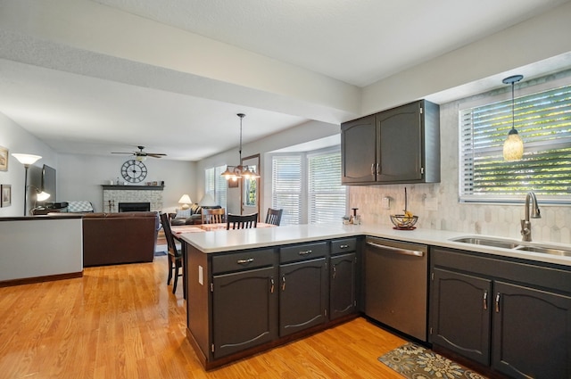 3383 Parkbrook Dr, Grove City, OH 43123 - kitchen with dishwasher, a peninsula, a fireplace, light wood-type flooring, and hanging light fixtures