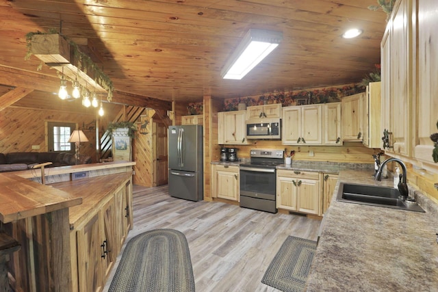 35640 Vickers Rd, Logan, OH 43138 - kitchen with appliances with stainless steel finishes, wooden ceiling, wooden walls, light wood finished floors, and decorative light fixtures