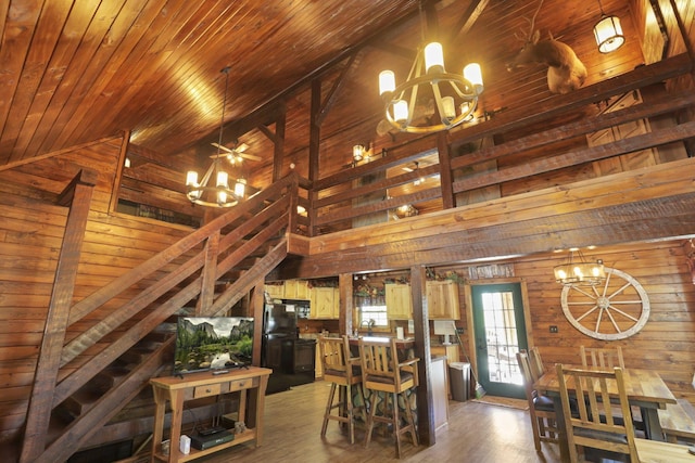 35640 Vickers Rd, Logan, OH 43138 - dining room featuring a chandelier, wood walls, light wood-style floors, wood ceiling, and high vaulted ceiling