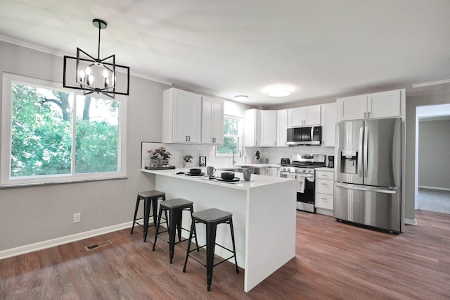 1370 Wiltshire Rd, Columbus, OH 43223 - kitchen with appliances with stainless steel finishes, a peninsula, a breakfast bar, backsplash, and white cabinetry