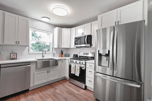 1370 Wiltshire Rd, Columbus, OH 43223 - kitchen with stainless steel appliances, light countertops, tasteful backsplash, white cabinetry, and light wood-style floors