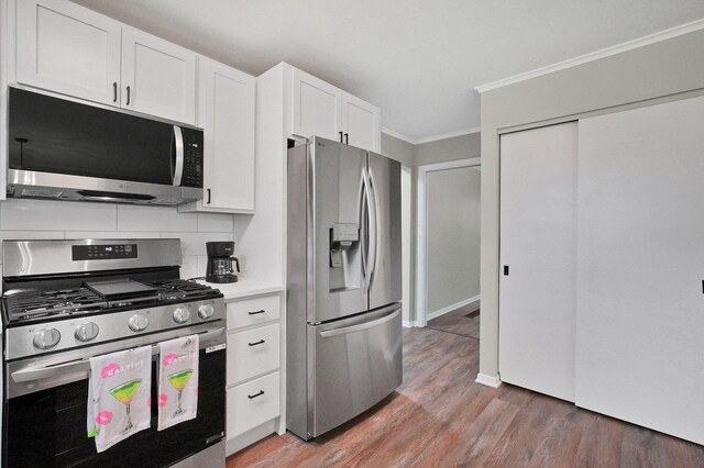 1370 Wiltshire Rd, Columbus, OH 43223 - kitchen with appliances with stainless steel finishes, ornamental molding, tasteful backsplash, white cabinets, and light wood-type flooring