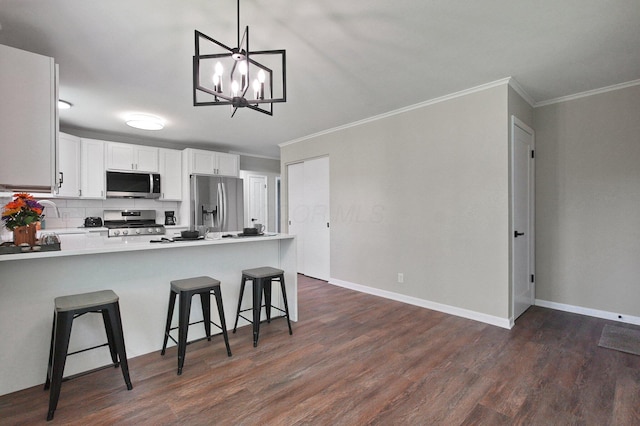 1370 Wiltshire Rd, Columbus, OH 43223 - kitchen with appliances with stainless steel finishes, crown molding, dark wood-style flooring, a peninsula, and a kitchen breakfast bar