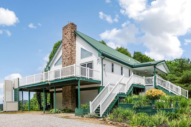 51801 State Route 671, Londonderry, OH 45647 - view of home's exterior with stairs, a garage, a chimney, driveway, and a metal roof