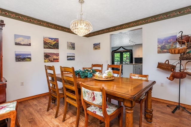 51801 State Route 671, Londonderry, OH 45647 - dining room with light wood finished floors, a chandelier, and a textured ceiling