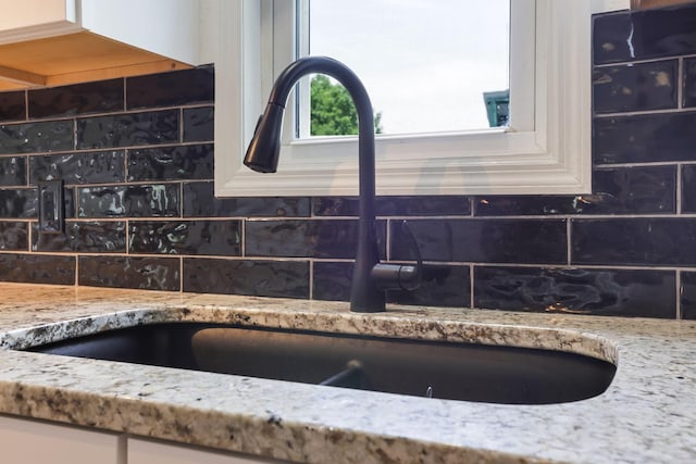 51801 State Route 671, Londonderry, OH 45647 - kitchen view of backsplash, light stone counters, and white cabinetry