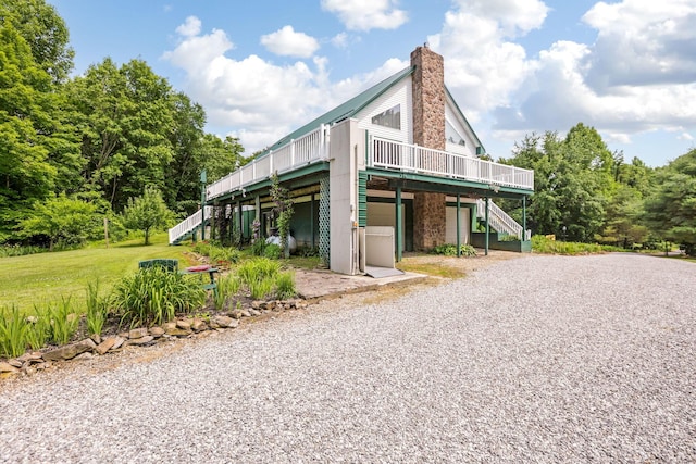 51801 State Route 671, Londonderry, OH 45647 - view of side of home featuring stairway, gravel driveway, a wooden deck, and a chimney
