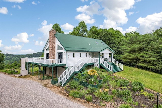 51801 State Route 671, Londonderry, OH 45647 - raised beach house with stairway, a chimney, a deck, a metal roof, and gravel driveway