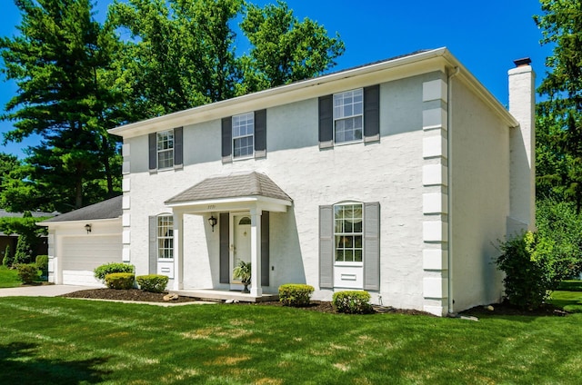 7771 Strathmoore Rd, Dublin, OH 43016 - view of front of property featuring a front lawn, a chimney, stucco siding, a garage, and concrete driveway