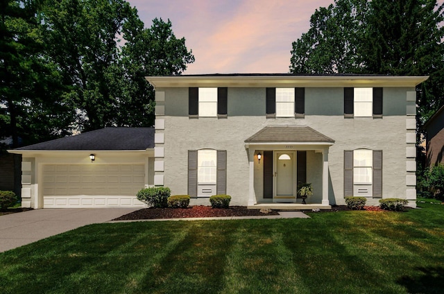 7771 Strathmoore Rd, Dublin, OH 43016 - view of front of home with concrete driveway, a garage, a yard, and stucco siding