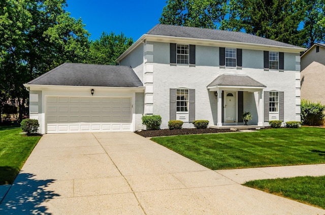 7771 Strathmoore Rd, Dublin, OH 43016 - view of front of property featuring an attached garage, concrete driveway, stucco siding, and a front lawn