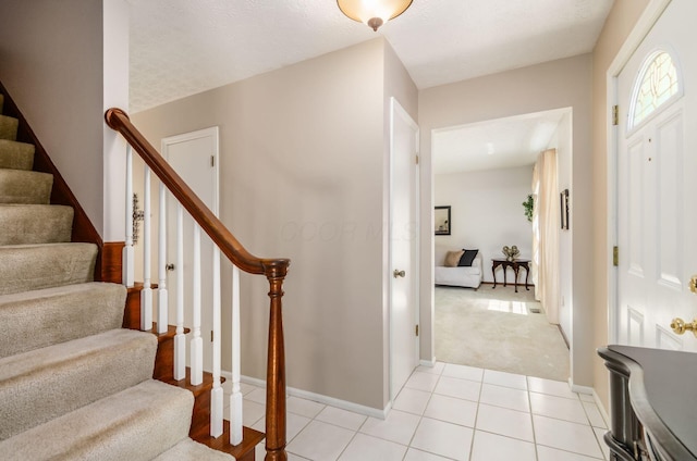 7771 Strathmoore Rd, Dublin, OH 43016 - foyer entrance with stairway, light tile patterned floors, and light carpet
