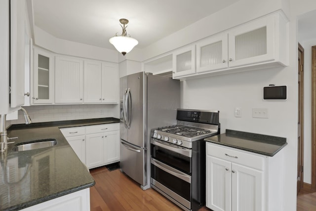 3505 Dresden St, Columbus, OH 43224 - kitchen featuring appliances with stainless steel finishes, white cabinets, wood finished floors, backsplash, and dark stone countertops