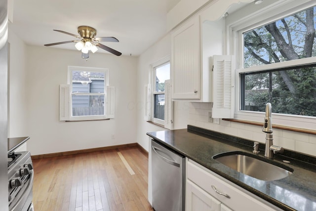 3505 Dresden St, Columbus, OH 43224 - kitchen with appliances with stainless steel finishes, tasteful backsplash, white cabinetry, ceiling fan, and light wood-style flooring
