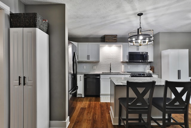 4634 State Route 61, Sunbury, OH 43074 - kitchen featuring stainless steel microwave, black dishwasher, freestanding refrigerator, decorative backsplash, and a breakfast bar area