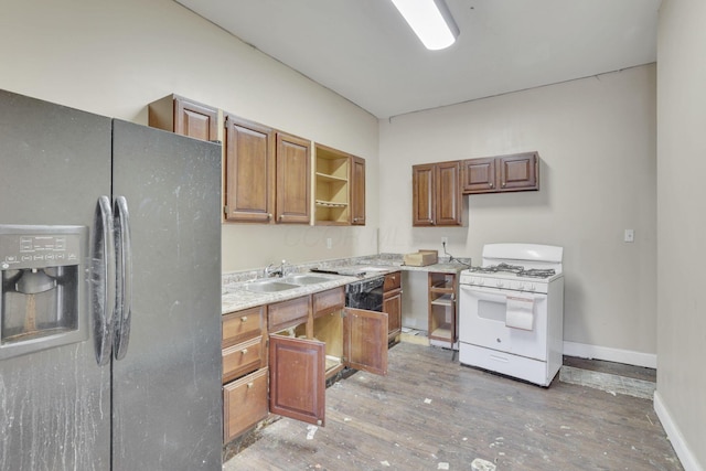 749-751 E Main St Unit 749, Columbus, OH 43205 - kitchen featuring stainless steel fridge, gas range gas stove, open shelves, brown cabinetry, and light wood-style flooring