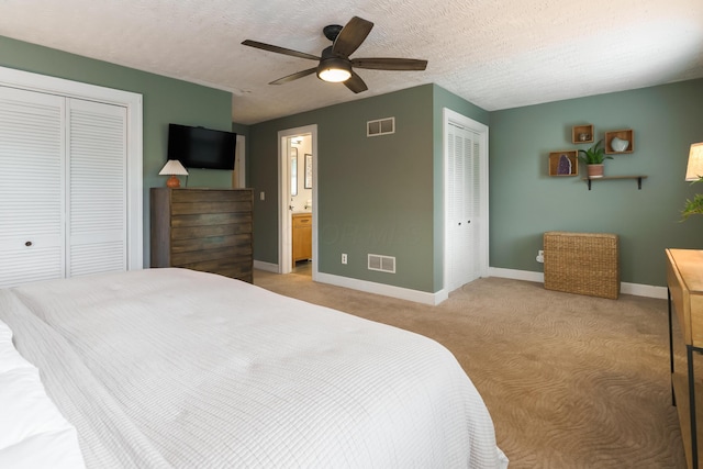 678 S Cassingham Rd, Columbus, OH 43209 - bedroom with light colored carpet, a ceiling fan, a textured ceiling, two closets, and ensuite bath