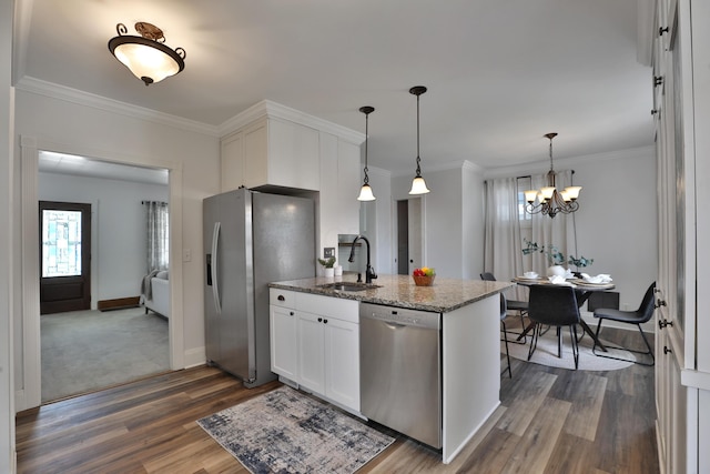 274 E Jenkins Ave, Columbus, OH 43207 - kitchen with stainless steel appliances, dark wood-style flooring, white cabinets, light stone counters, and ornamental molding