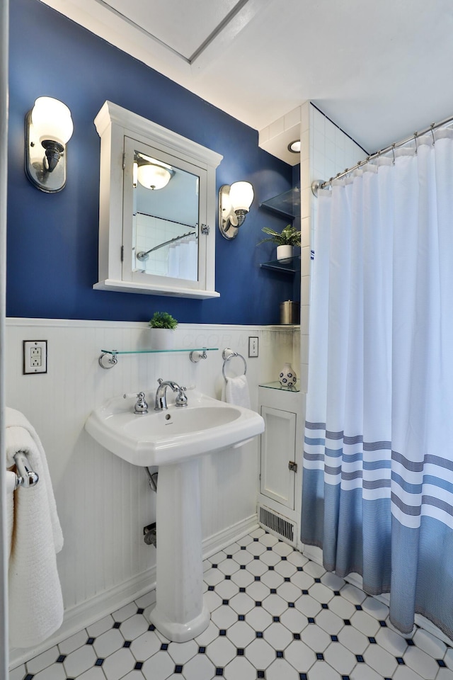 274 E Jenkins Ave, Columbus, OH 43207 - full bathroom with tile patterned floors, wainscoting, and a shower with curtain