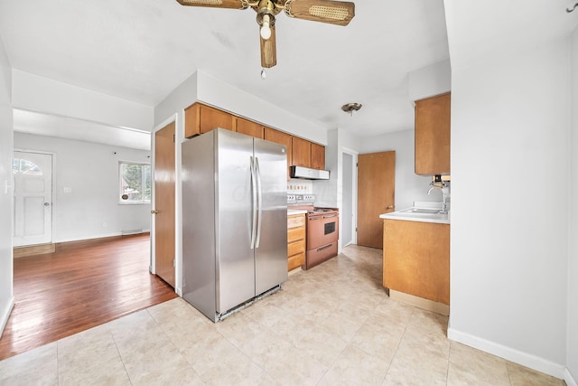 1799 Ormond Ave, Columbus, OH 43224 - kitchen featuring freestanding refrigerator, white range with electric cooktop, brown cabinets, ceiling fan, and range hood