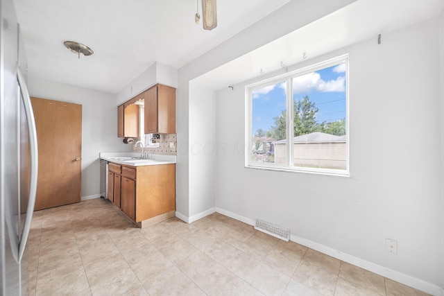 1799 Ormond Ave, Columbus, OH 43224 - kitchen featuring stainless steel fridge, light countertops, and brown cabinetry
