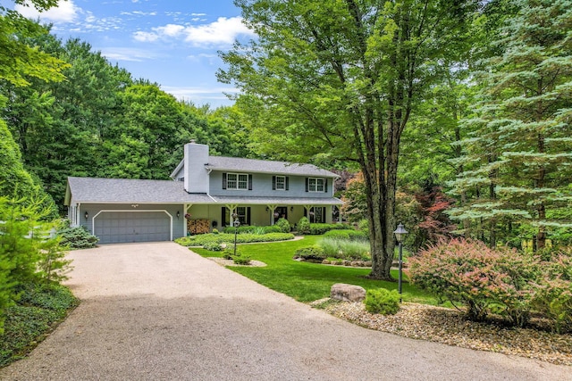 2211 Welsh Hills Rd NE, Granville, OH 43023 - view of front of home featuring an attached garage, a chimney, driveway, a front yard, and a wooded view