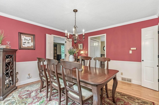 2211 Welsh Hills Rd NE, Granville, OH 43023 - dining area featuring a chandelier, light wood-style floors, ornamental molding, and a textured ceiling