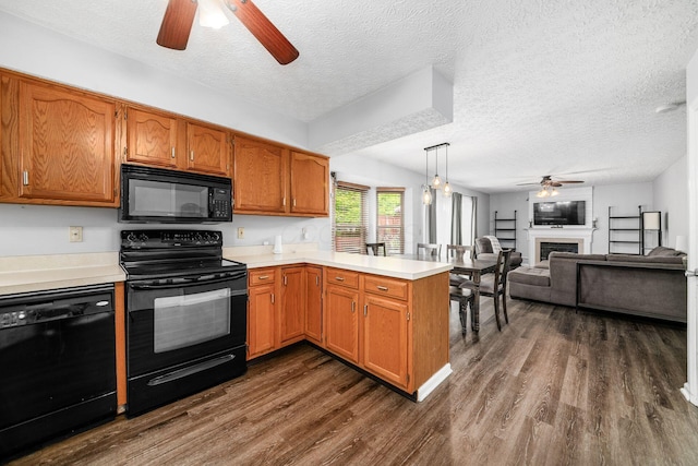 1191 Wexford Green Blvd, Columbus, OH 43228 - kitchen with black appliances, a ceiling fan, a peninsula, light countertops, and a textured ceiling