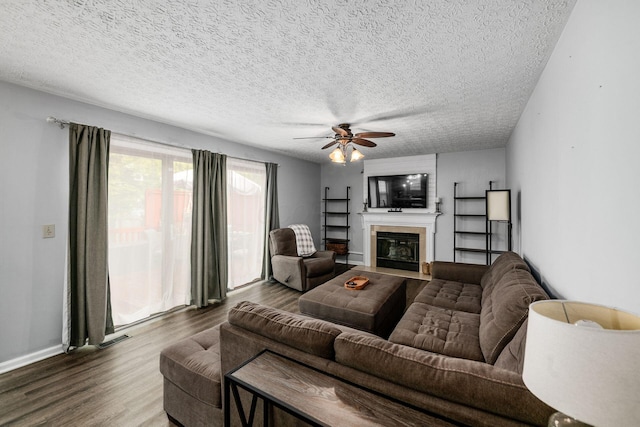 1191 Wexford Green Blvd, Columbus, OH 43228 - living area featuring wood finished floors, a textured ceiling, a fireplace with flush hearth, and ceiling fan