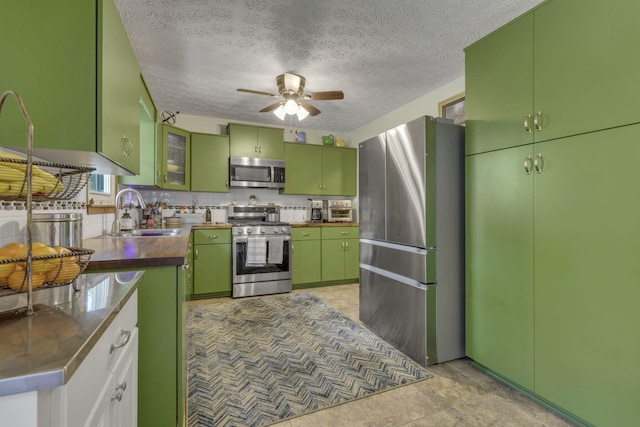 1588 Constitution Dr, Newark, OH 43055 - kitchen with appliances with stainless steel finishes, green cabinets, ceiling fan, decorative backsplash, and a textured ceiling