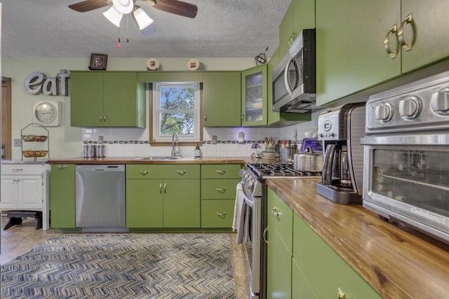1588 Constitution Dr, Newark, OH 43055 - kitchen with stainless steel appliances, butcher block countertops, decorative backsplash, a textured ceiling, and a ceiling fan
