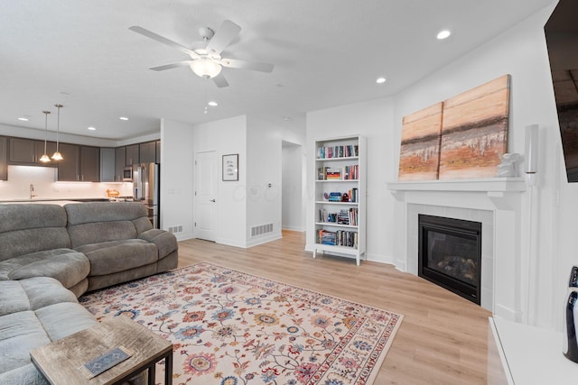 6452 Rockhold Dr, Westerville, OH 43081 - living room with light wood-style floors, a ceiling fan, a fireplace, and recessed lighting