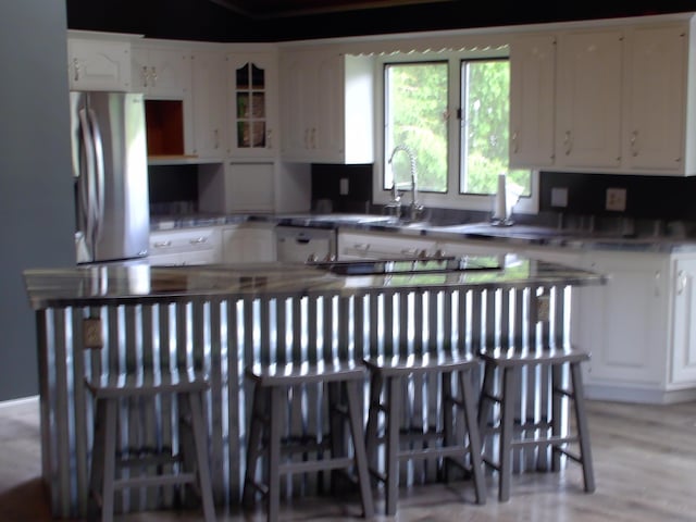 1110 Burr Oak Blvd, Nelsonville, OH 45764 - kitchen featuring freestanding refrigerator, white cabinets, dishwasher, glass insert cabinets, and light wood finished floors