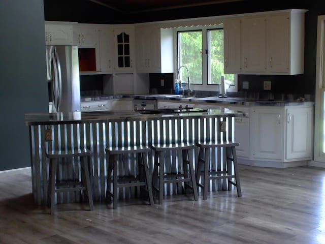 1110 Burr Oak Blvd, Nelsonville, OH 45764 - kitchen with white cabinets, light wood-type flooring, and freestanding refrigerator