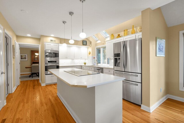 7661 Norhill Rd, Columbus, OH 43235 - kitchen featuring appliances with stainless steel finishes, a kitchen island, white cabinets, light countertops, and light wood-style floors