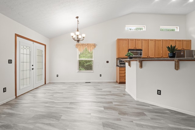 1296 Blacksmith Dr, Westerville, OH 43081 - kitchen featuring appliances with stainless steel finishes, lofted ceiling, a breakfast bar area, french doors, and hanging light fixtures