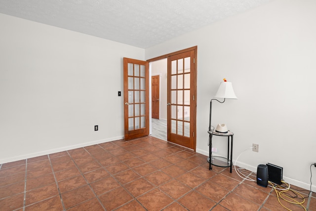 1296 Blacksmith Dr, Westerville, OH 43081 - empty room featuring french doors, a textured ceiling, and dark tile patterned floors