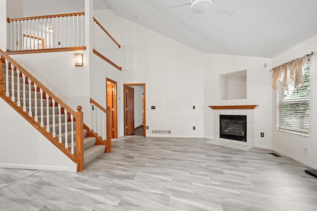 1296 Blacksmith Dr, Westerville, OH 43081 - unfurnished living room with ceiling fan, stairs, high vaulted ceiling, and a tile fireplace